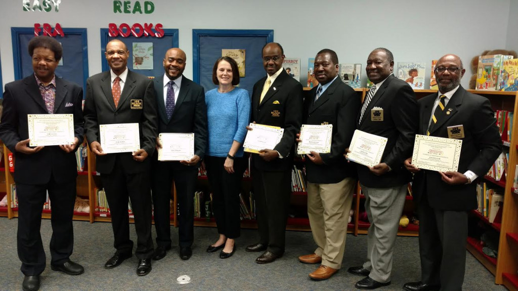 From left to right : Commissioner Bill Proctor, Walt McNeil, Representative Alan Williams, assistant principal Terri Martin, Col. (Ret.) Ronald M. Joe, Sherwood Brown, Selvin Cobb and Judge Errol Powell, pose with certificates after reading to students.