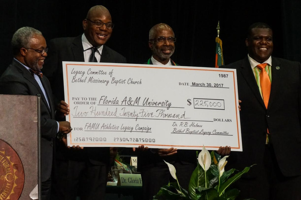 Four of the key players in staging the Legacy Banquet (from left) George Cotton, executive director of FAMU Foundation; Rev. R.B. Holmes; Larry Robinson, FAMU’s interim president; and athletic director Milton Overton shows the proof of money raised by the event. Photo by Elegance Davis  